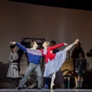 Ballet dancers perform a duet center stage, captivating the crowd in winter clothing as they bring the Snow Queen’s enchanting story to life.