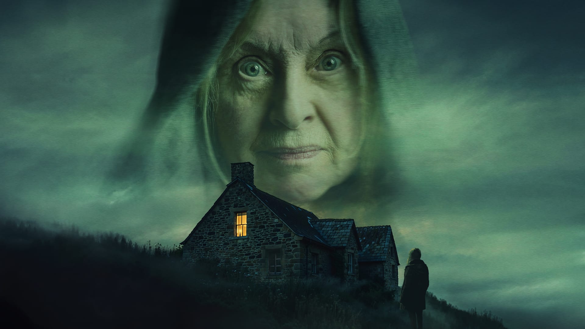 A stone house with one lit window sits under a dark, cloudy sky. A large, transparent face of an older woman looms above, while a lone figure stands outside.