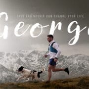 A man runs alongside a dog in a mountainous landscape, with the Blue Programme message "True friendship can change your life. George" overlaid.
