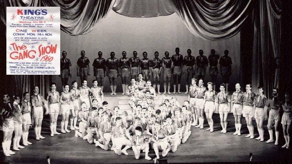 A large group of performers in uniform pose in formation on stage with curtains, promoting "The Gang Show 1960" at King's Theatre, as shown in the event poster inset.