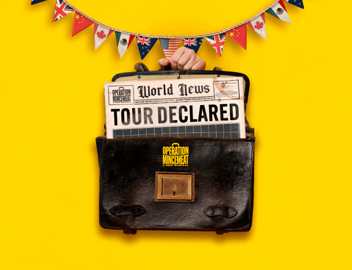 A hand holds a briefcase with a newspaper reading "Tour Declared" sticking out, against a yellow background with international flag bunting above.