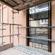 Scaffolding set up outside a stone building showcasing the new slot window on the exterior of the King's building.