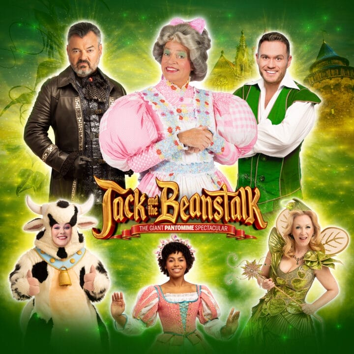 Six cast members in costume for "Jack and the Beanstalk" pose against a green background with castle elements, showcasing characters including Jack, the Dame, the Cow, and a fairy.