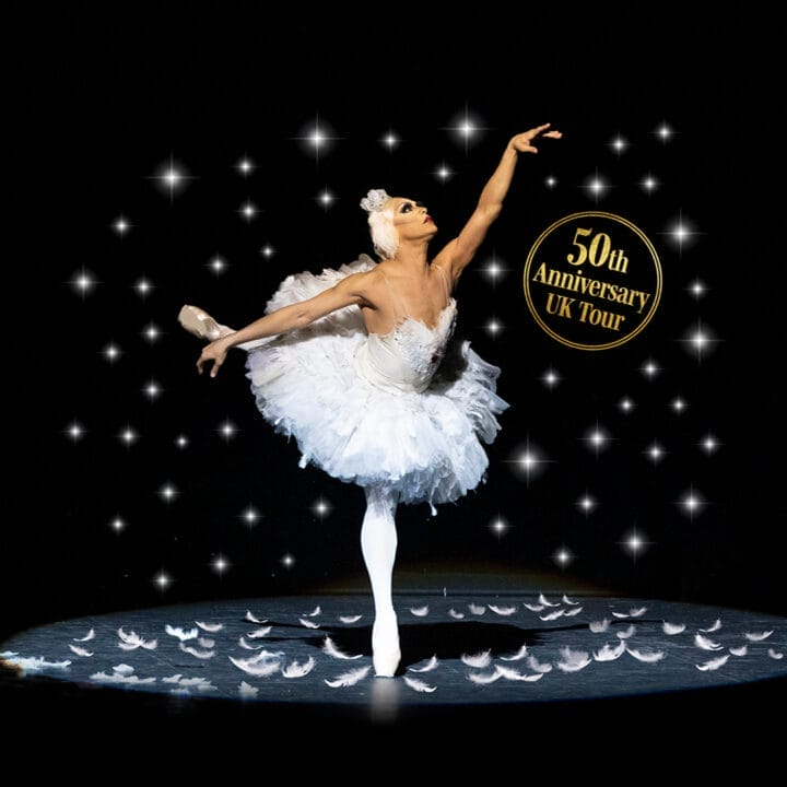 A ballerina in a white tutu poses on stage under spotlights, surrounded by feather-like shapes, with a "50th Anniversary UK Tour" badge in the background—celebrating the artistry of Les Ballets Trockadero and Monte Carlo ballet traditions.