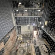 View from above of the King's Theatre Redevelopment, showing a multi-story industrial construction site with scaffolding, cables, wooden boards, and equipment scattered across the floor.