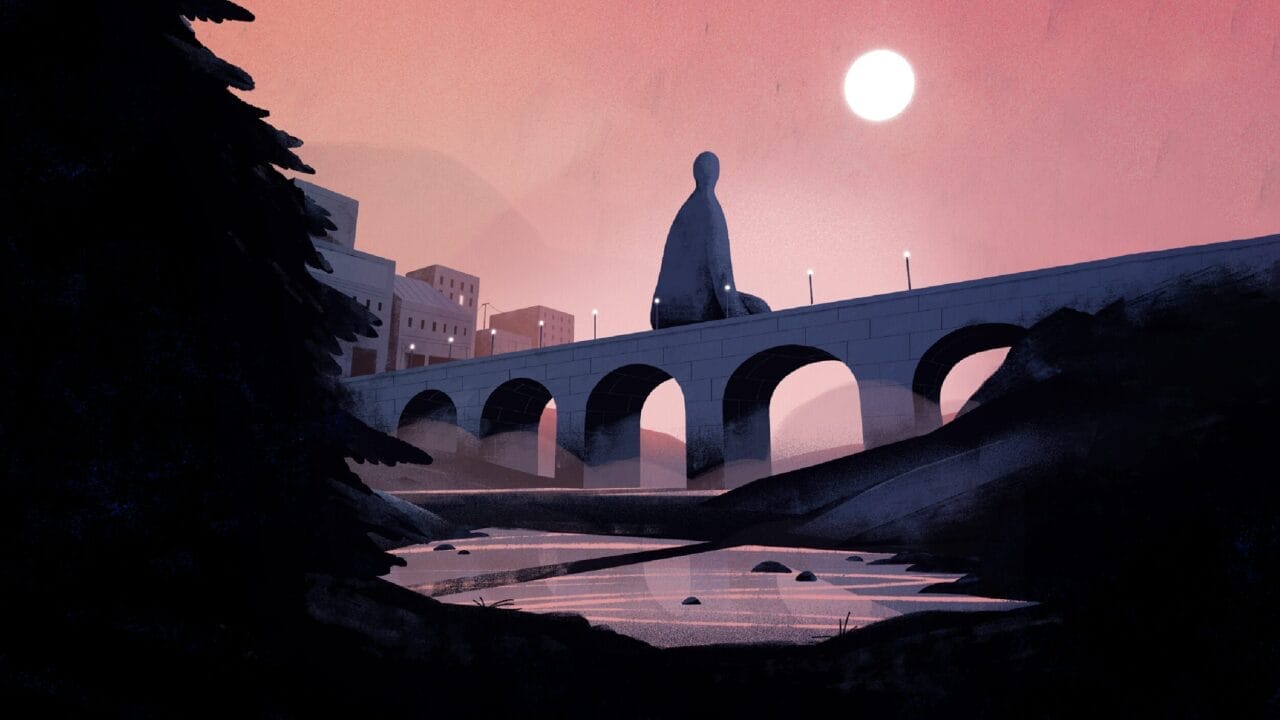 A giant statue sits on a stone bridge over a river at sunset, with buildings in the background and a tree in the foreground.