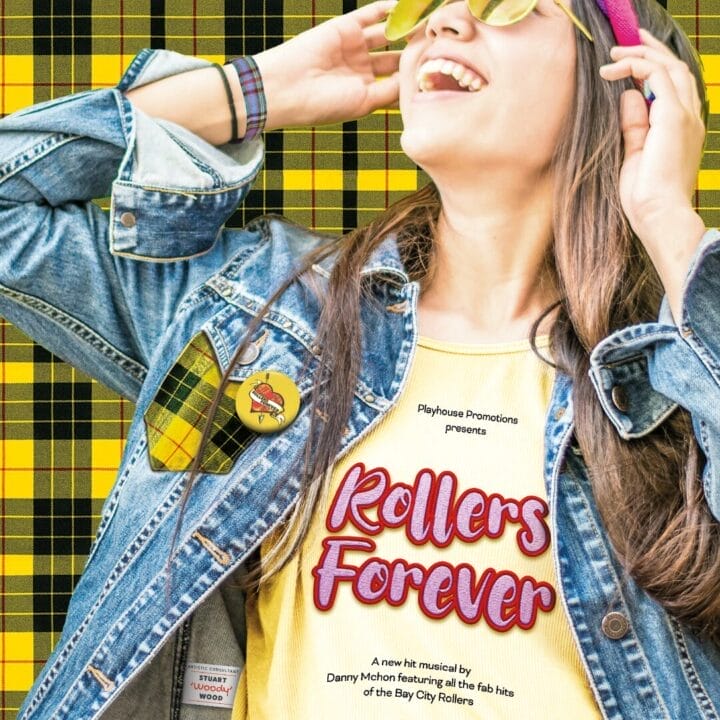 Young woman in sunglasses and a denim jacket, wearing a yellow "Rollers Forever" T-shirt, stands smiling against a vibrant yellow and black plaid background, proudly showing her love for Rollers.