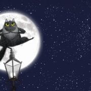 Toto the Ninja Cat, a black cartoon feline with yellow eyes, sits cross-legged atop a streetlamp, silhouetted against a full moon in a starry night sky above city buildings.