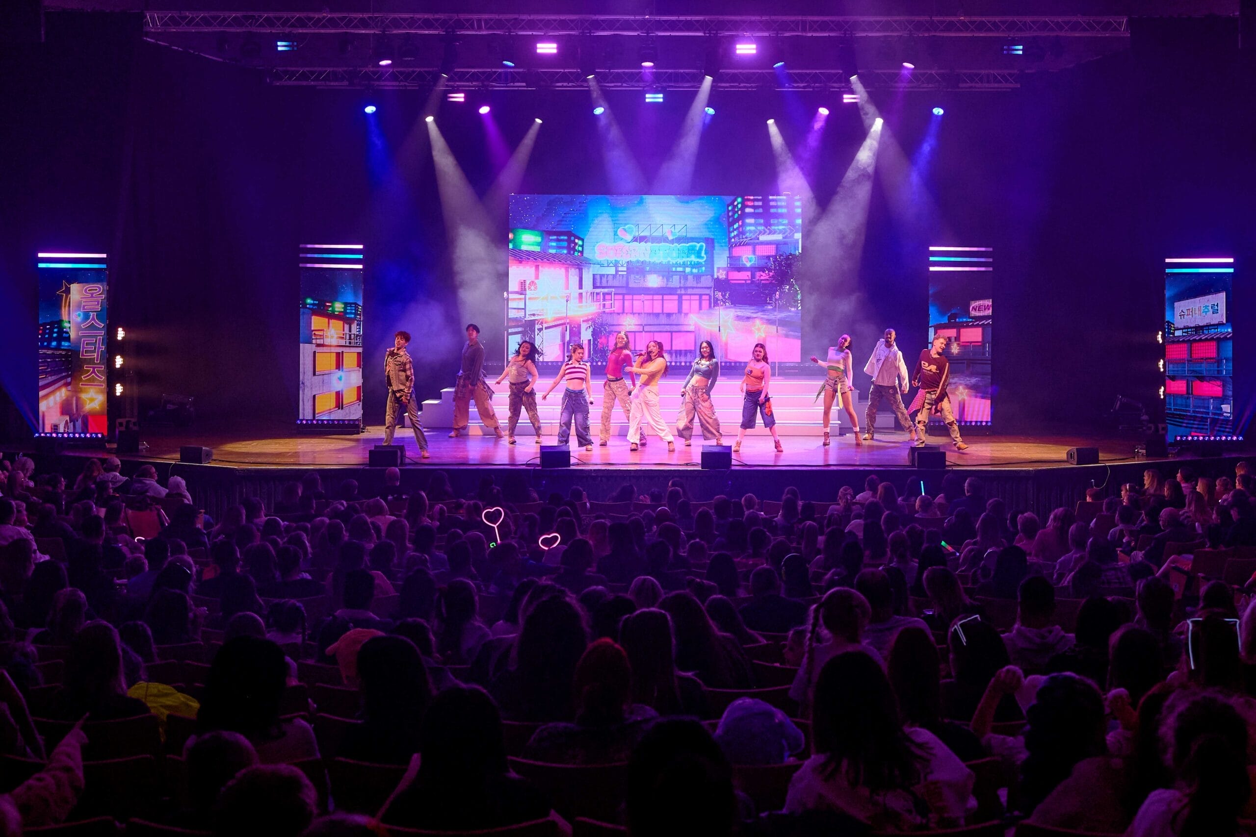 K-Pop all stars - young people dancing on the stage in funky clothes and bright lights